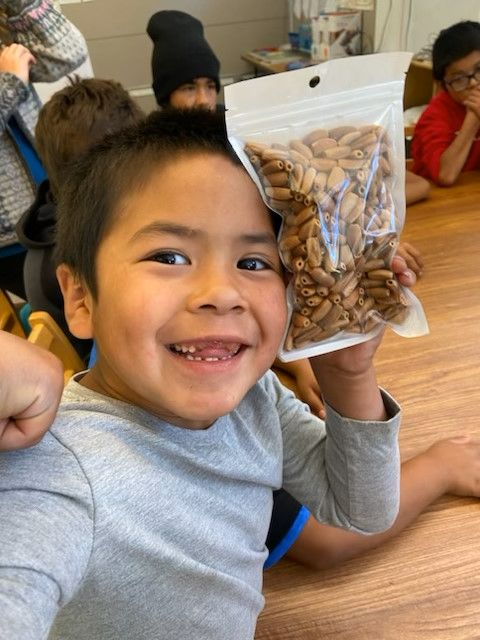 Child holding handmade pinecone beads